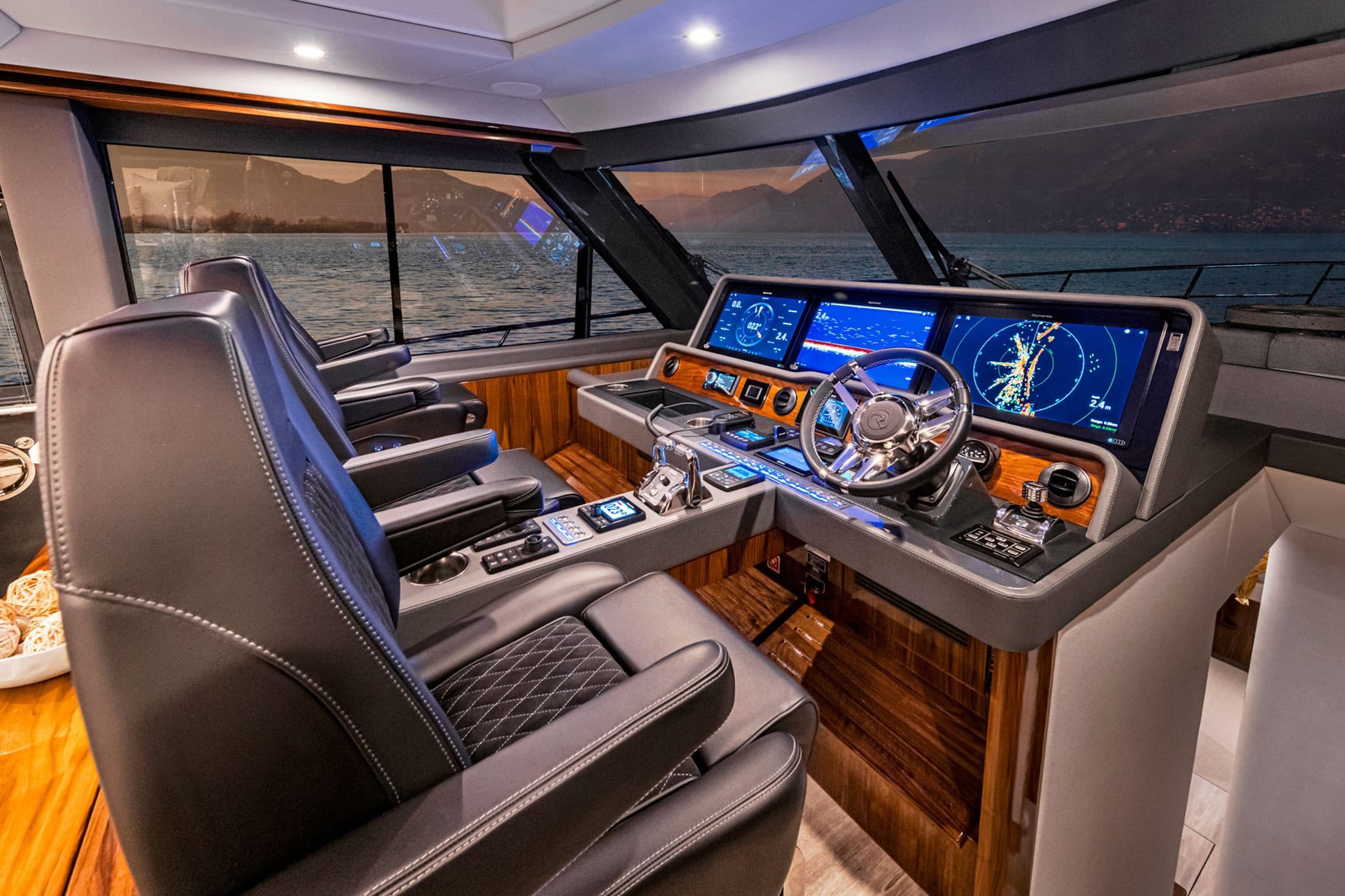 Triple seats and a state-of-the art helm aboard the Riviera 645 SUV.