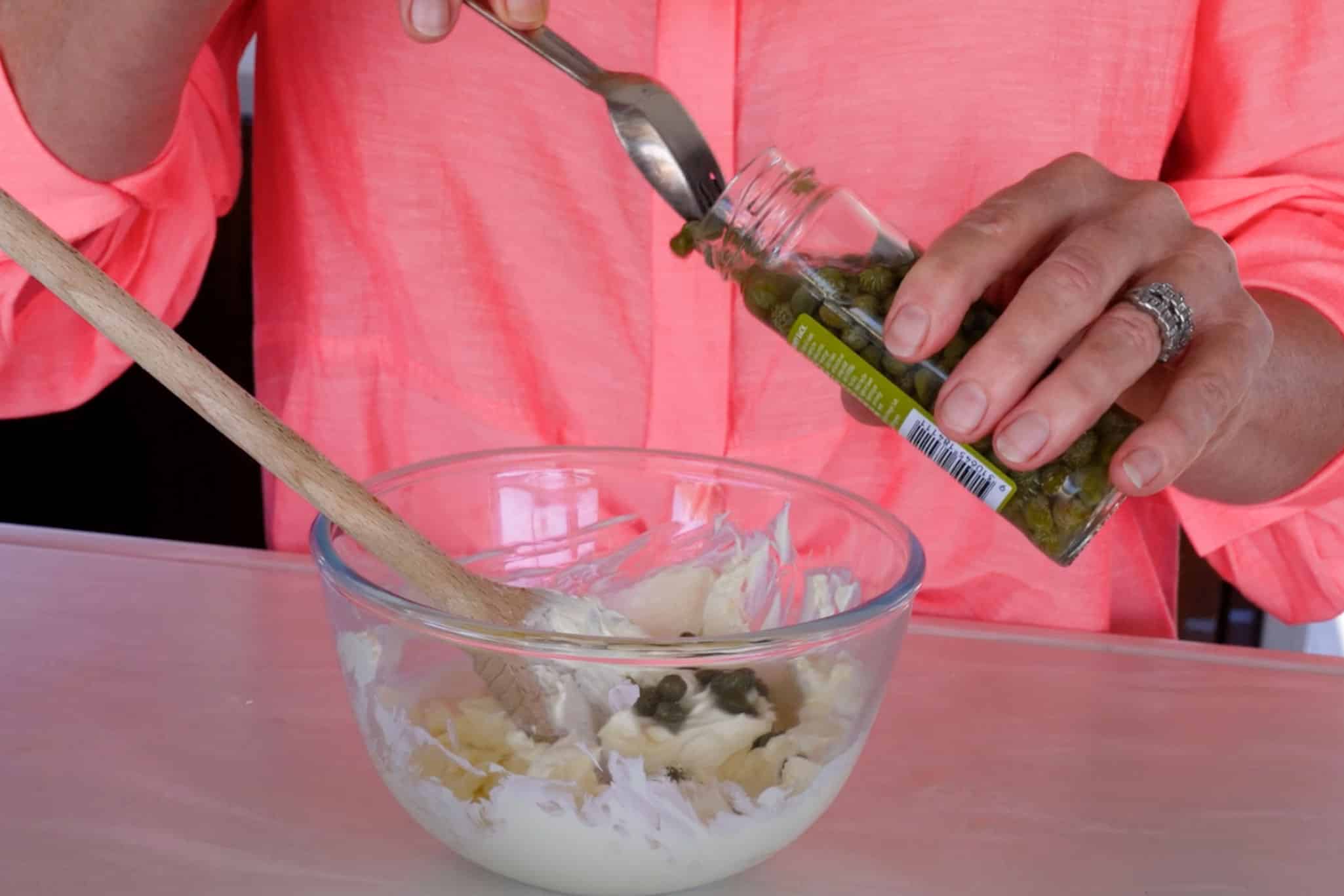 Adding capers to the cream cheese.